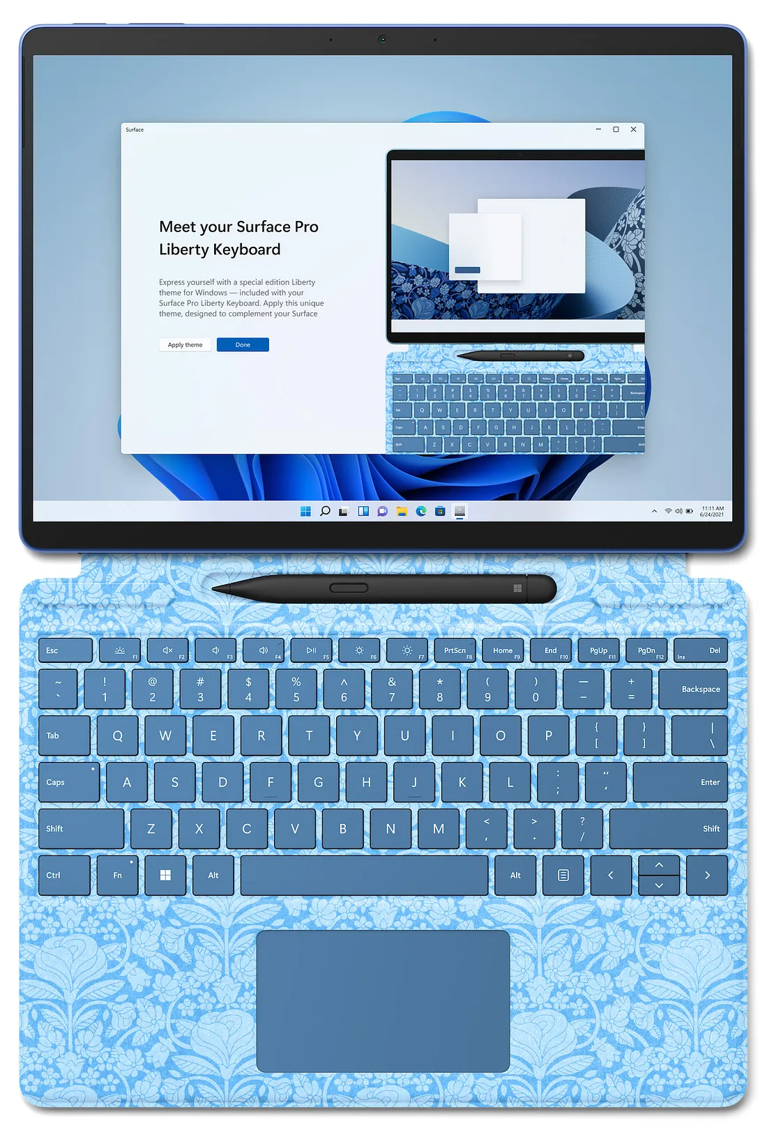 A Microsoft Surface Pro tablet with a digital pen is shown alongside a detachable keyboard featuring a blue floral design. The screen displays a promotional webpage for the Liberty Keyboard.