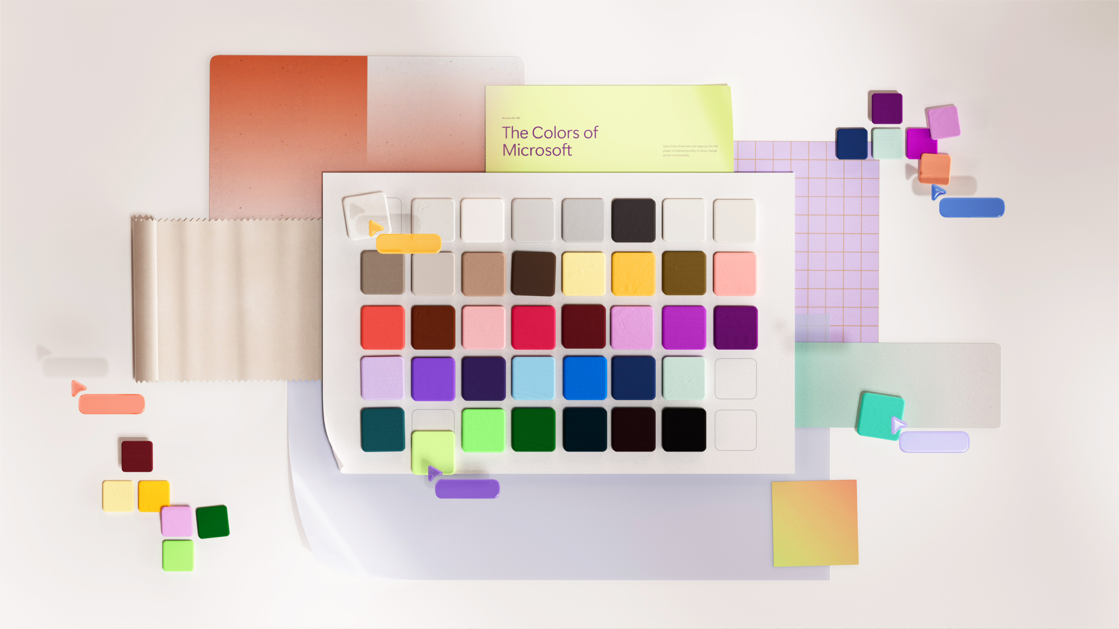 An assortment of color swatches titled "The Colors of Microsoft" arranged in a grid. Various sticky notes, small color chips, and papers with hues ranging from pastel to vibrant tones are scattered around the main focus, creating a visually dynamic scene.