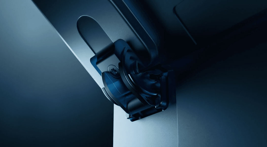 Close-up view of a dark-colored, adjustable hinge mechanism on a device mount, captured in soft lighting to highlight its sleek and modern design. The image showcases the precision and engineering in the hinge's construction.